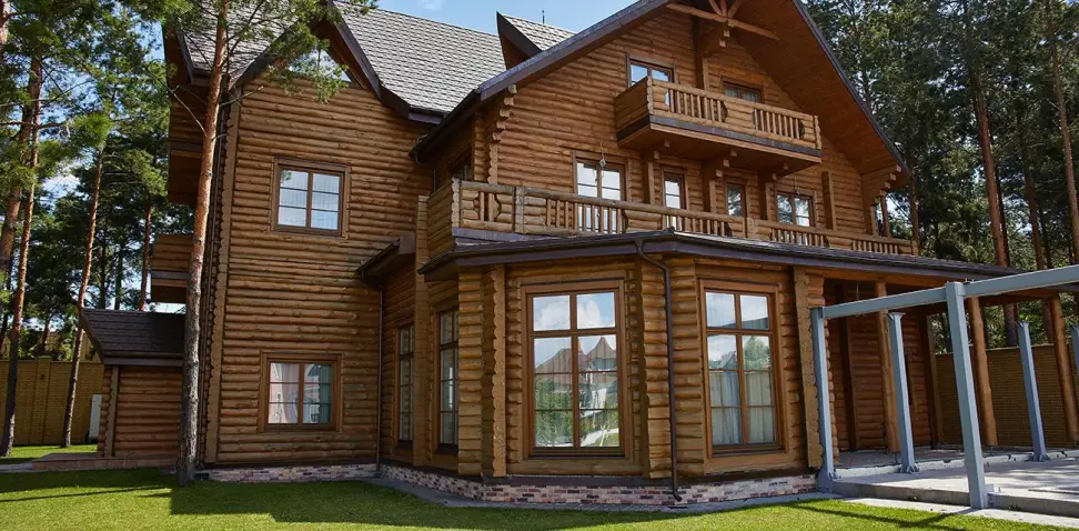 Великий дерев'яний будинок з просторою верандою.
